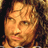 Pixelated static image of a person's face with warm tones and dark background, likely from a low-resolution source or stylized rendering.