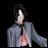 Pixelated figure with dark hair in gray jacket over pink top, standing against black background with 'Anime IM' and 'com' text.