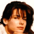 Pixelated close-up of a person with dark brown hair and light skin, showing the head and upper shoulders against a white background.