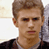 Static pixelated image of a person's face with brown hair and dark clothing, displayed on a light background.