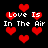 Red pixelated hearts float against a black background with repeated text 'Love Is In The Air' in white pixelated font.