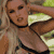 Pixelated static image of a person in a bikini top with visible torso and arm, set against blurred background elements.