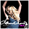A woman with long blonde hair in a blue sleeveless top raises both arms above her head against a black background, with stylized text overlay.