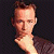 Pixelated image of a person with light skin and brown hair against dark background, next to green text reading Original Icons .com in stylized font.
