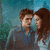 Two people in a close embrace with one person's hand on the other's head, set against dark and light backgrounds.