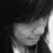 A grayscale pixelated image of a stylized face with closed eyes and dark hair against a black background.