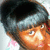 Pixelated close-up of a person with dark hair and light skin, wearing a gray headband against a blurred background.