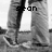 Black-and-white pixelated image of a person's lower body in jeans and sneakers, with text overlays changing across frames.