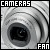 Pixelated grayscale image of a camera lens with text "CAMERAS" at top and "FAN" at bottom, rendered in blocky digital style.