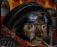Animated sequence of a figure in dark helmet and red collar against fiery background, showing subtle facial expression shifts.