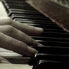 Close-up of hands playing piano keys with fingers positioned on black and white keys.