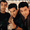 Six show three men in dark clothing against a string-lit background, with yellow text appearing sequentially