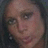 Pixelated close-up of a person's face with visible eyes, nose, and mouth against dark background.