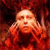 A pixelated figure with closed eyes and a neutral expression, wearing a red garment against a dark red background.
