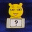 Yellow cartoon cat head on beige base with question mark, play button, and card symbols