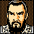 Pixelated static icon of a man's face with black hair, beard, and mustache against an orange dot pattern background, featuring white pixel accents on the left and right sides.