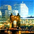 Pixelated static image of a bridge with towers and water, set against a blue sky with clouds.