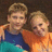 Pixelated photo of two people in casual clothing on a pink background with text overlays.