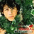 Pixelated image of a person with dark hair wearing green clothing against a blurred background.