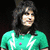 A person with long dark hair appears in multiple poses wearing green and blue shirts against varied backgrounds.