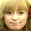 four showing a person with light brown hair and bangs, red hair accessories, transitioning from neutral to broad smiles across frames