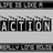 Static black-and-white image showing repeated 'ACTION' text in pixelated block letters with horizontal lines above and below.