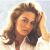 Pixelated image of a person with long brown hair, light skin, and a neutral expression, wearing a white top against a light background.