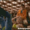 Animated pixelated figure in brown outfit with orange accents, standing on blue ground beneath textured ceiling.