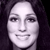 Pixelated grayscale portrait of a person with dark hair, neutral expression, and visible facial features including eyes, nose, and mouth.