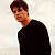 A pixelated image split into two sections: a person in dark clothing on the left and green text on a dark background on the right.
