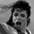 Black-and-white split image of a person with two distinct facial expressions, accompanied by pixelated text reading 'i love michael jackson' below.