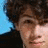 A 48x48 pixel animated buddy icon showing a person with curly hair in two frames: left frame has no heart, right frame adds a red heart over the chest area.