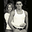 Two people in white tank tops stand side-by-side against a dark background, with text reading "TRUE LOVE<3" on a green to the right