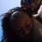 A person with long dark hair and a headband is shown in four against a light blue background, displaying subtle facial expression changes