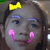Pixelated close-up of a stylized face with gray skin, blue eyebrows, pink blush marks, and a yellow bow on the left side.