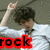 Pixelated image of a person with dark curly hair wearing white clothing, making a hand gesture near their head, with red text reading 'rock' at the bottom.