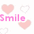 Pixelated pink and white heart shapes surround text reading 'Smile' in pink and 'It looks good on you' in red.