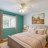 Pixelated static image showing a room interior with teal wall trim, a white ceiling fixture, and a bed with light-colored bedding.