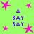 A static image with a bright green background featuring pink star shapes and blue text reading "A BAY BAY" in four vertical