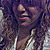 A person with long curly hair and a white top appears in multiple overlapping frames showing slight head movement.