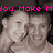 Pixelated grayscale image of two smiling people with pink text reading You Make M Smile above them.