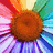 Pixelated flower with brown center and multicolored petals in red, pink, purple, blue, green, and yellow hues.