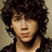 A pixelated image of a person with curly brown hair wearing dark clothing, overlaid with text in white and black blocks.