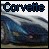 Pixelated static icon featuring the word "Corvette" in blue and black pixel art above a blurred image of a car on a road with mountains.