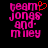 Pixelated text 'team jonas and miley' in pink with a red heart symbol above the 'm' on the left side, displayed against black background.