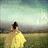 A pixelated figure in a yellow dress stands with back to viewer, facing a hazy landscape under pale sky.