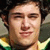 Static pixelated image of a person with dark hair, light skin tone, and a neutral expression wearing green and yellow clothing.
