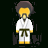Pixelated figure in white karate uniform with dark belt, yellow accents on sleeves and pants, brown hair, standing against black background.