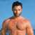 Pixelated image of a shirtless man with short dark hair and a beard, standing against a solid light blue background.