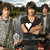 Group of young men in outdoor setting with text overlays changing across frames; one man wears black shirt with white heart symbol.
